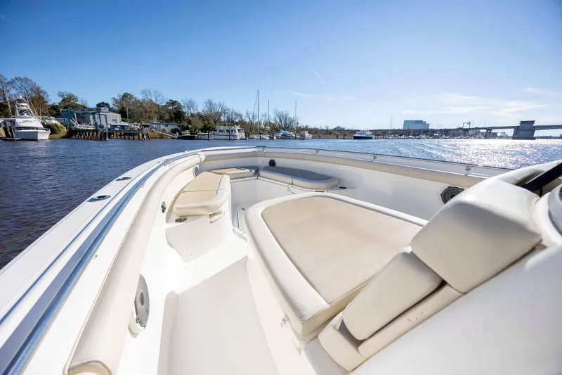  Yacht Photos Pics 2019 Boston Whaler 350 Outrage boat interior with seating, docked by a scenic waterfront.