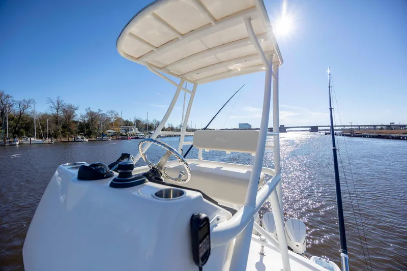  Yacht Photos Pics 2019 Boston Whaler 350 Outrage boat on sunny waterway, featuring helm and fishing rods.