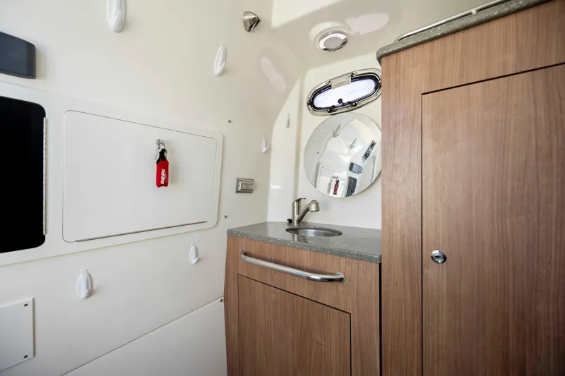  Yacht Photos Pics 2019 Boston Whaler 350 Outrage cabin interior with sink, mirror, and storage.