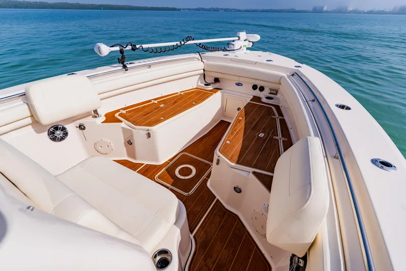  Yacht Photos Pics 2021 Grady-White Canyon 306 boat interior with teak flooring and cushioned seating.