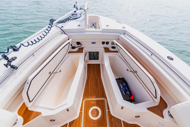  Yacht Photos Pics 2021 Grady-White Canyon 306 boat interior with open storage compartments and teak flooring.
