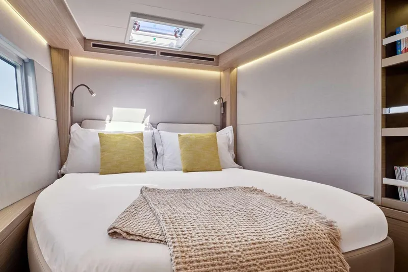 Saam III Yacht Photos Pics Luxurious bedroom interior of 2025 Lagoon LAGOON 51 yacht with modern design and cozy bedding.