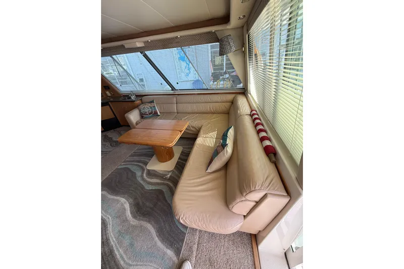 At Ease Yacht Photos Pics Luxurious interior of 1997 Bayliner 47 Motoryacht with leather seating and wooden table.