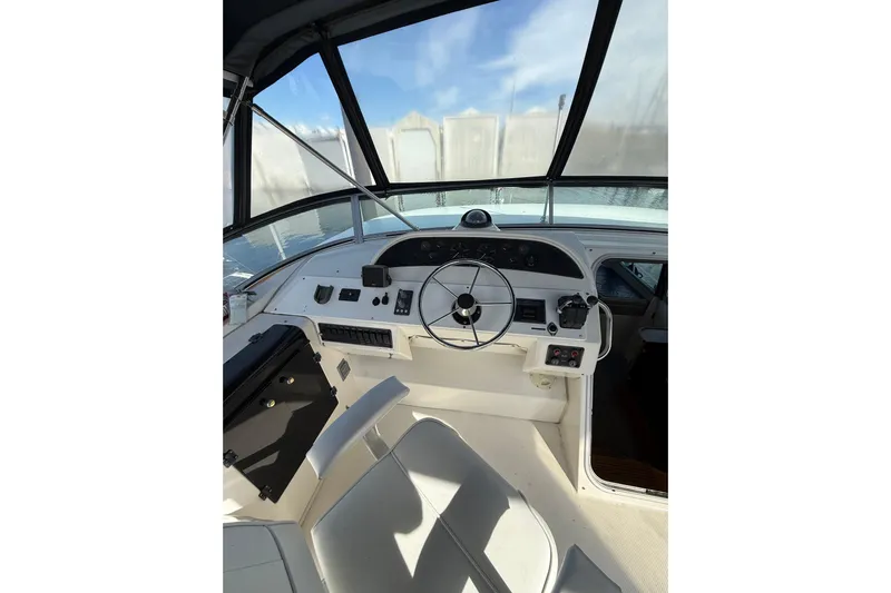 At Ease Yacht Photos Pics 1997 Bayliner 47 Motoryacht helm with steering wheel and control panel.