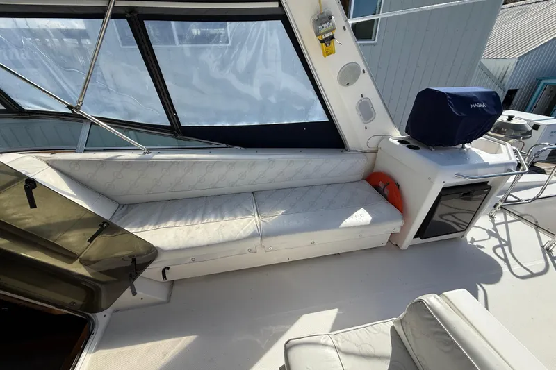 At Ease Yacht Photos Pics 1997 Bayliner 47 Motoryacht interior with white seating and covered grill.