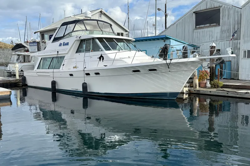At Ease Yacht Photos Pics 1997 Bayliner 47 Motoryacht docked at marina, reflecting on calm water.