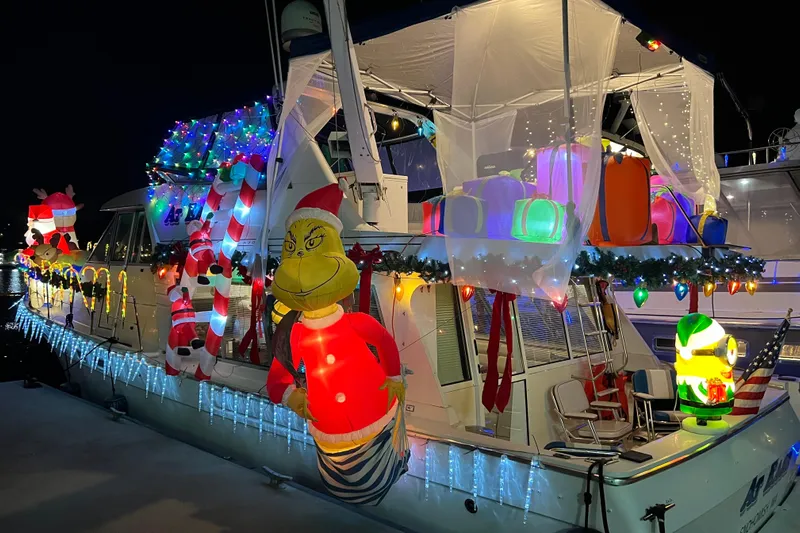 At Ease Yacht Photos Pics 1997 Bayliner 47 Motoryacht festively decorated with colorful Christmas lights and inflatable figures.