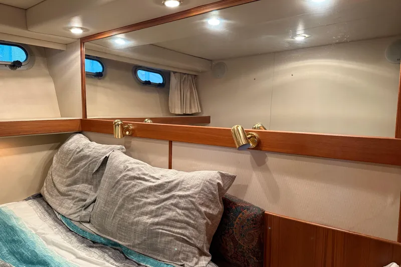 At Ease Yacht Photos Pics Cozy cabin interior of 1997 Bayliner 47 Motoryacht with mirror and bedding.