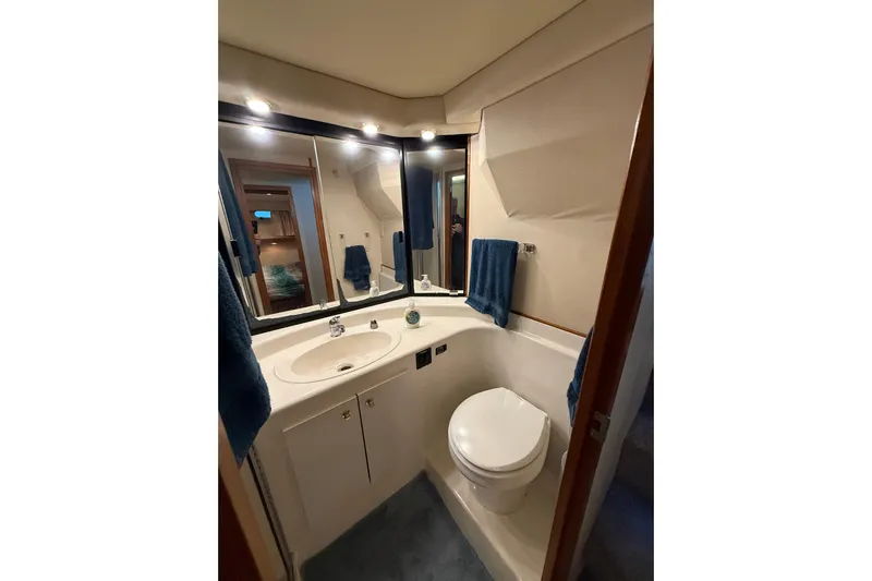 At Ease Yacht Photos Pics Bathroom interior of 1997 Bayliner 47 Motoryacht with sink, mirror, and toilet.