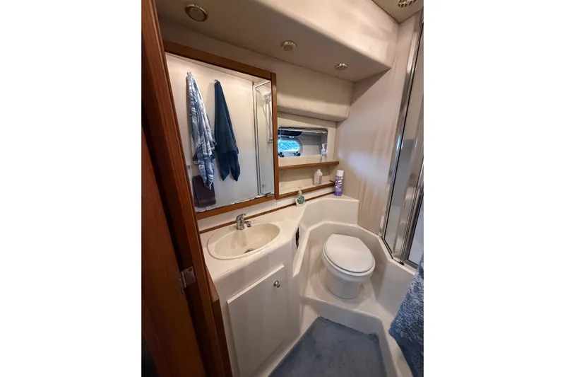 At Ease Yacht Photos Pics Bathroom interior of 1997 Bayliner 47 Motoryacht with sink, toilet, and mirror.