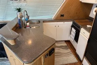 At Ease Yacht Photos Pics 1997 Bayliner 47 Motoryacht kitchen with modern appliances and sleek countertops.