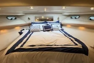 At Ease Yacht Photos Pics Luxurious bedroom interior of 1997 Bayliner 47 Motoryacht with elegant bedding.
