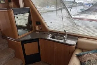 At Ease Yacht Photos Pics Interior of 1997 Bayliner 47 Motoryacht with kitchenette and marina view.