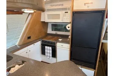 At Ease Yacht Photos Pics 1997 Bayliner 47 Motoryacht kitchen with modern appliances and sleek countertops.