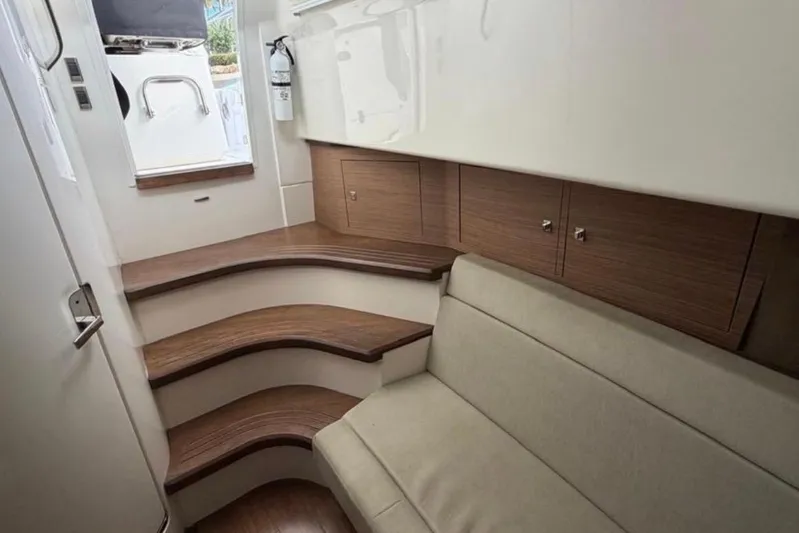  Yacht Photos Pics Interior of 2017 Boston Whaler 420 Outrage, featuring wooden steps and beige seating.