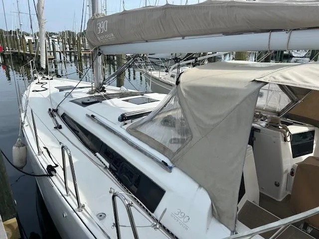 Sirene Yacht Photos Pics 2019 Dufour 390 GL sailboat docked at marina, featuring beige canopy and sleek design.