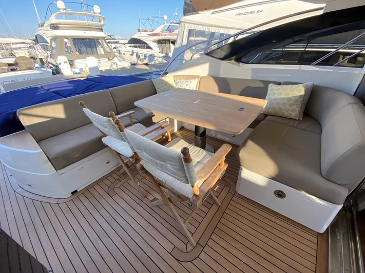  Yacht Photos Pics Luxury seating area on 2013 Princess V57 yacht with wooden deck and table.