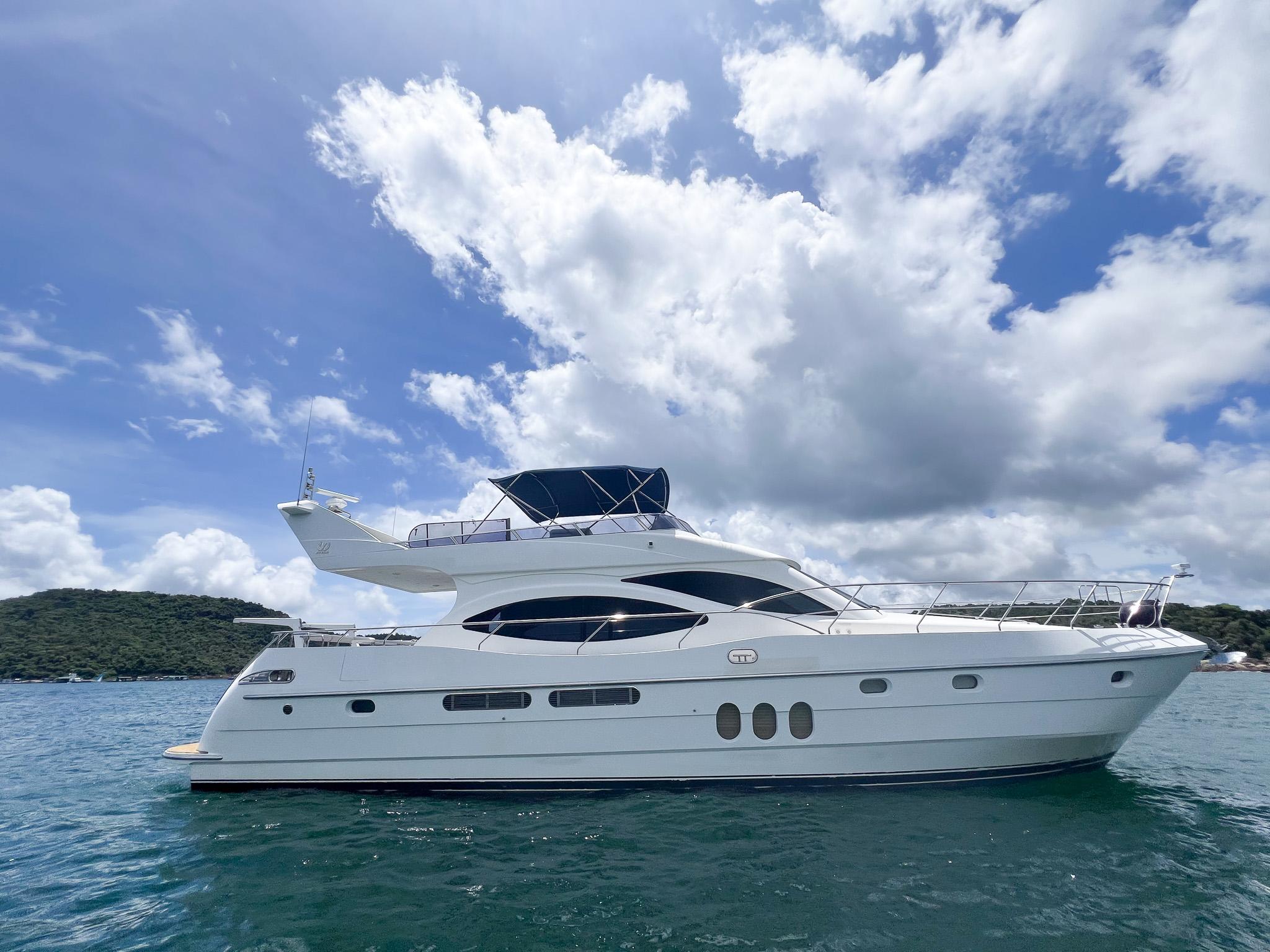 2005 Vitech 65 yacht on calm water under a partly cloudy sky.