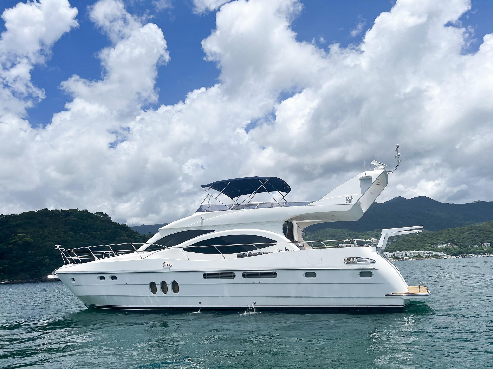 2005 Vitech 65 yacht on water, under a partly cloudy sky.