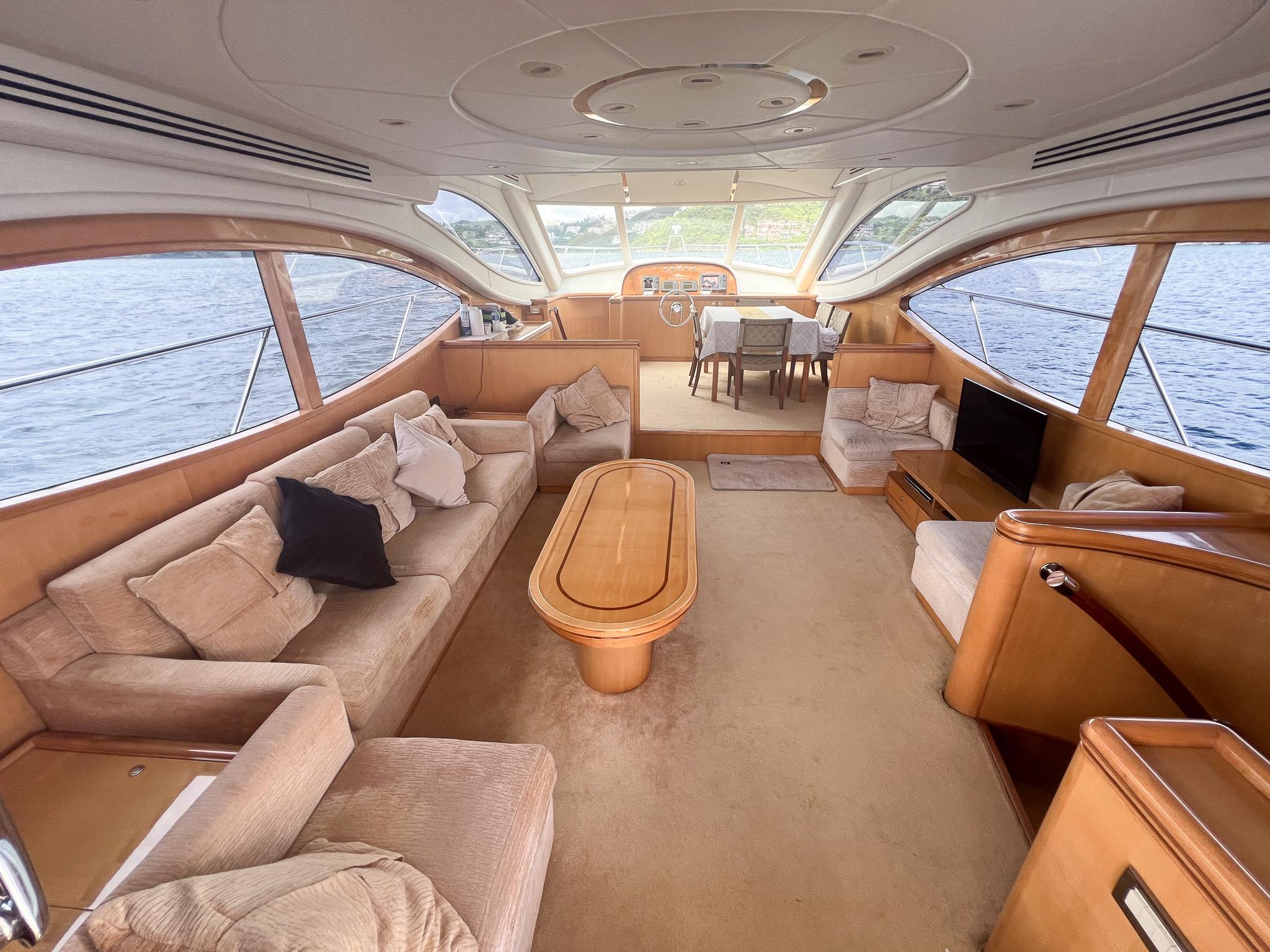 Luxurious interior of a 2005 Vitech 65 yacht with elegant seating and panoramic windows.