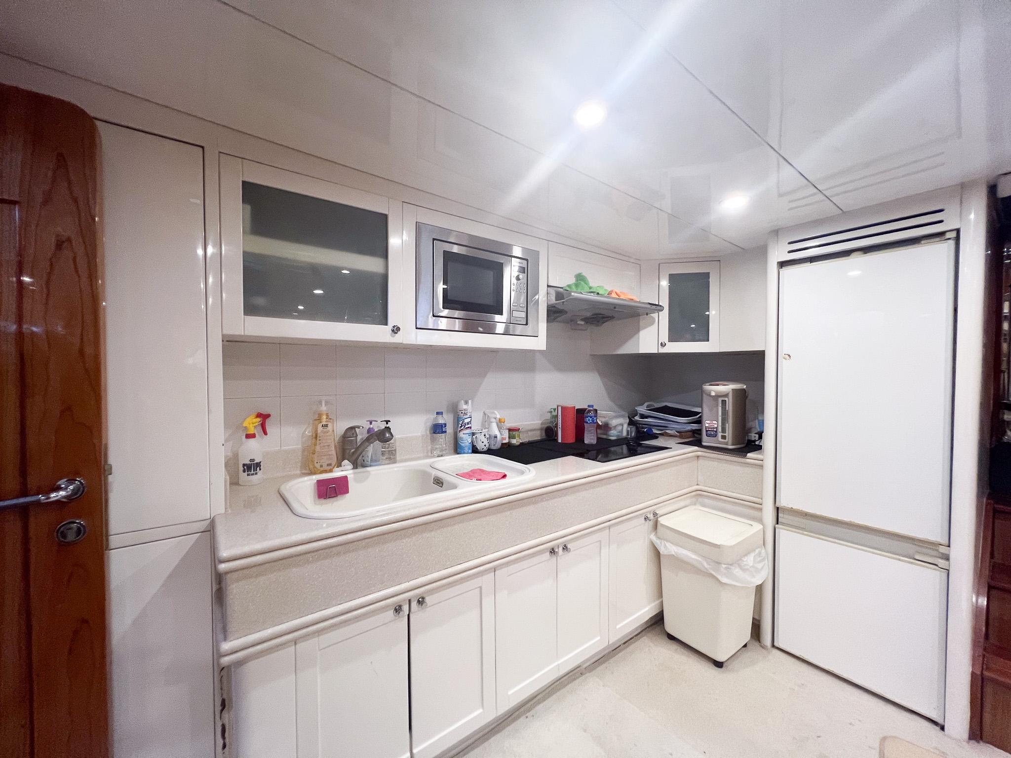 Modern kitchen interior on a 2005 Vitech 65 yacht, featuring sleek cabinetry and appliances.