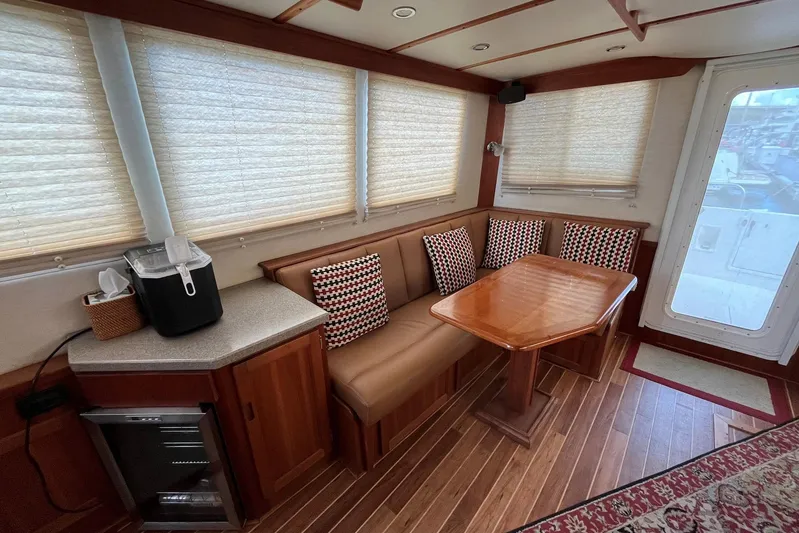 Dinky Dau Yacht Photos Pics 2007 Nordic Tug 42 interior with dining area, wooden table, and cushioned seating.