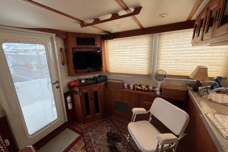 Dinky Dau Yacht Photos Pics 2007 Nordic Tug 42 interior with cozy seating, TV, and nautical decor.