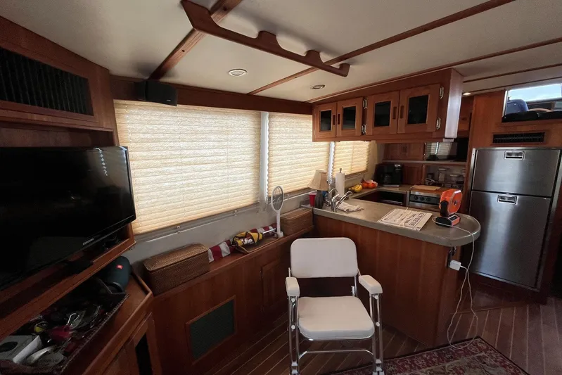 Dinky Dau Yacht Photos Pics Interior of 2007 Nordic Tug 42 with kitchen, chair, and TV.