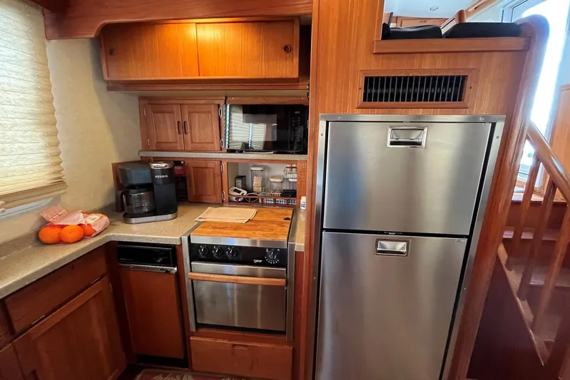 Dinky Dau Yacht Photos Pics 2007 Nordic Tug 42 galley with wooden cabinetry, stainless steel appliances, and countertop essentials.