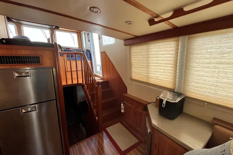Dinky Dau Yacht Photos Pics Interior of 2007 Nordic Tug 42 with wooden stairs and modern kitchen appliances.