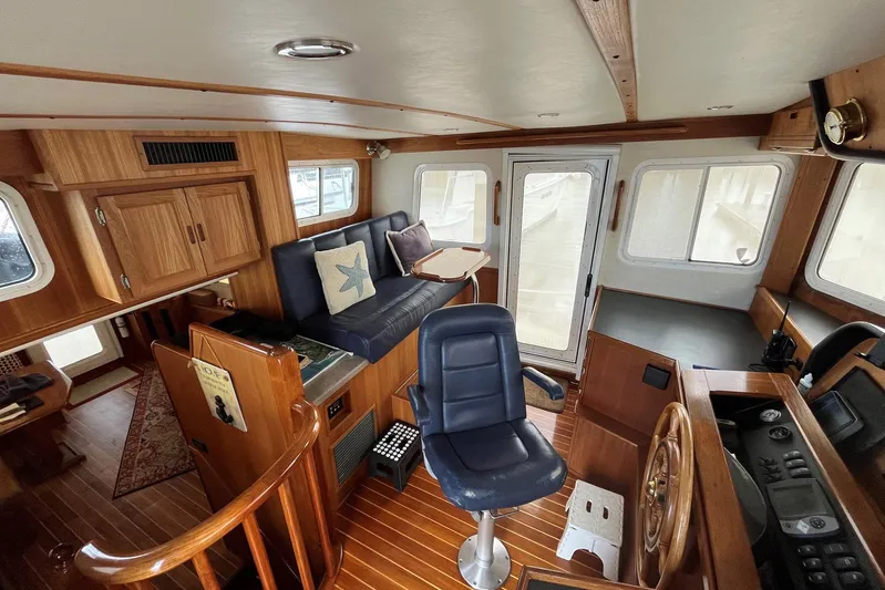 Dinky Dau Yacht Photos Pics Pilothouse of 2007 Nordic Tug 42 with wood interior and blue seating.