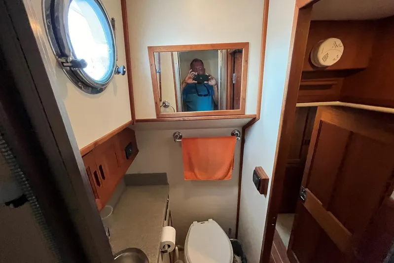 Dinky Dau Yacht Photos Pics Bathroom interior of 2007 Nordic Tug 42 with porthole and wooden cabinetry.