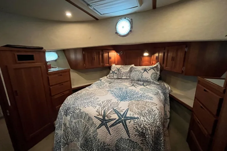 Dinky Dau Yacht Photos Pics Cozy bedroom in 2007 Nordic Tug 42 with nautical-themed bedding and wooden cabinetry.