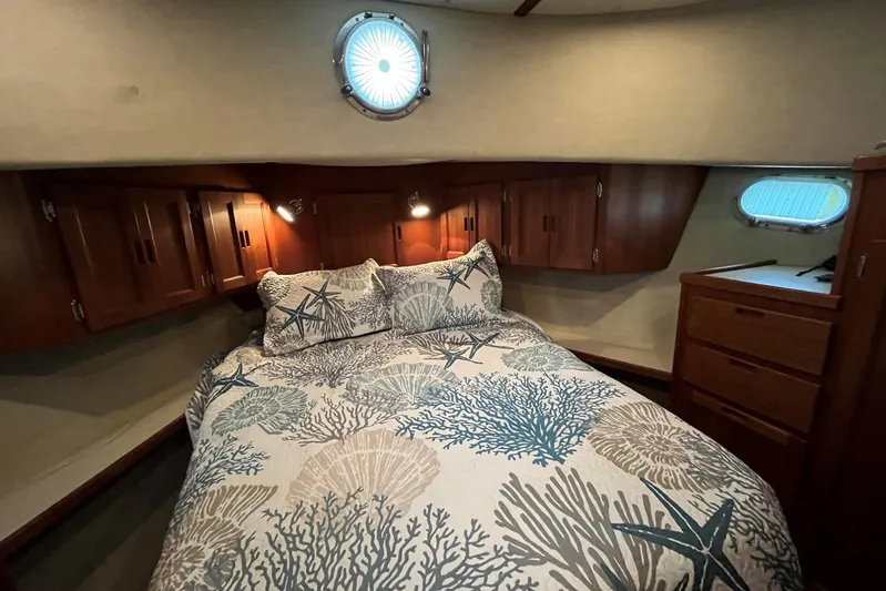 Dinky Dau Yacht Photos Pics Cozy bedroom in 2007 Nordic Tug 42 with nautical-themed bedding and wooden cabinetry.