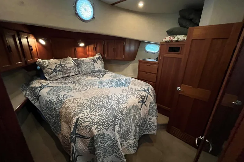Dinky Dau Yacht Photos Pics Cozy bedroom in 2007 Nordic Tug 42 with nautical-themed bedding and wooden cabinetry.