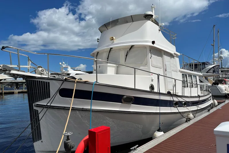 Dinky Dau Yacht Photos Pics 2007 Nordic Tug 42 docked at marina under blue sky.