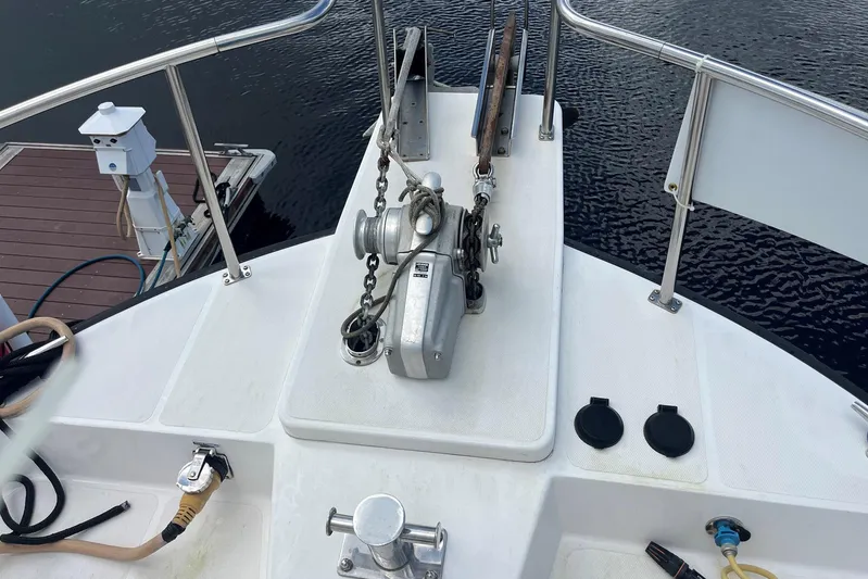 Dinky Dau Yacht Photos Pics 2007 Nordic Tug 42 boat deck with anchor winch and railing, docked by the water.