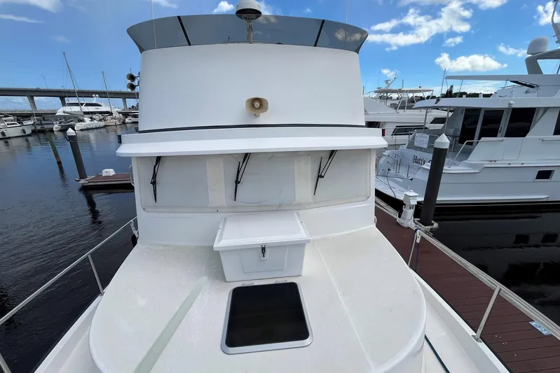 Dinky Dau Yacht Photos Pics 2007 Nordic Tug 42 docked at marina, showcasing upper deck and clear sky.