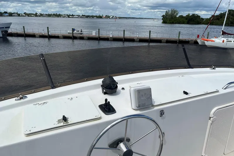 Dinky Dau Yacht Photos Pics 2007 Nordic Tug 42 helm with steering wheel, dock view, and overcast sky.