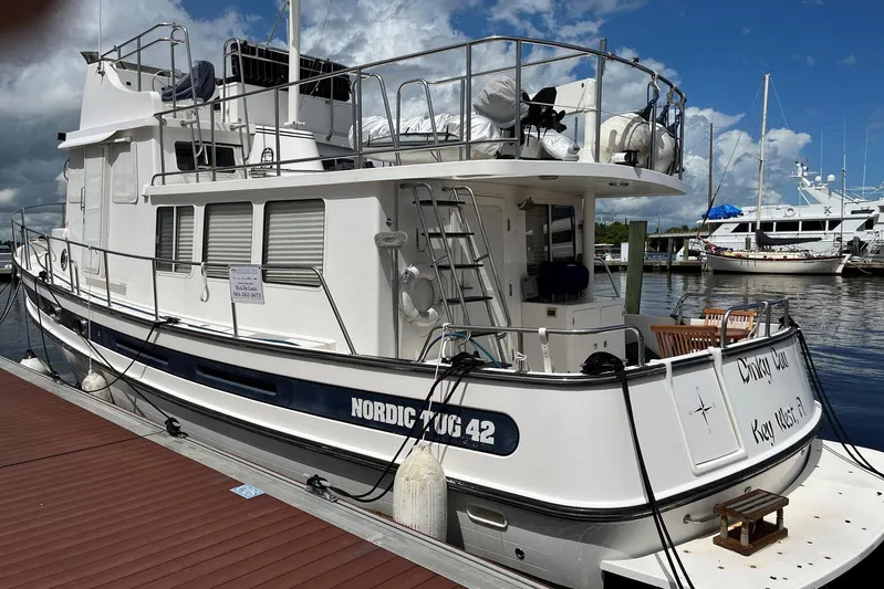 Dinky Dau Yacht Photos Pics 2007 Nordic Tug 42 docked at marina under cloudy sky.