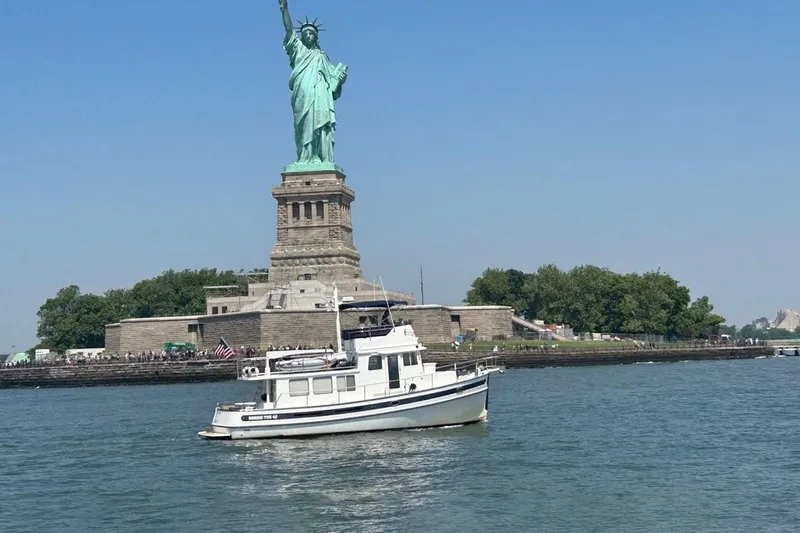 Dinky Dau Yacht Photos Pics Nordic Tug 42 (2007) near Statue of Liberty on a clear day.