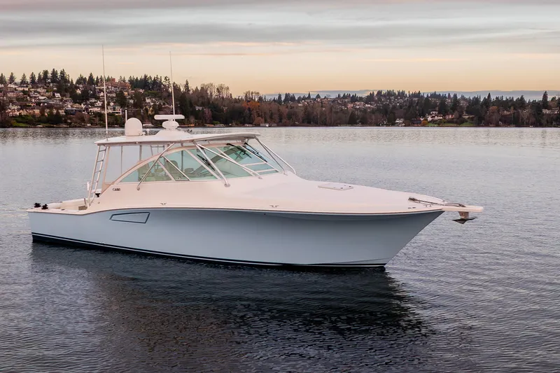  Yacht Photos Pics 2006 Cabo 40 Express boat on calm water with scenic shoreline background.