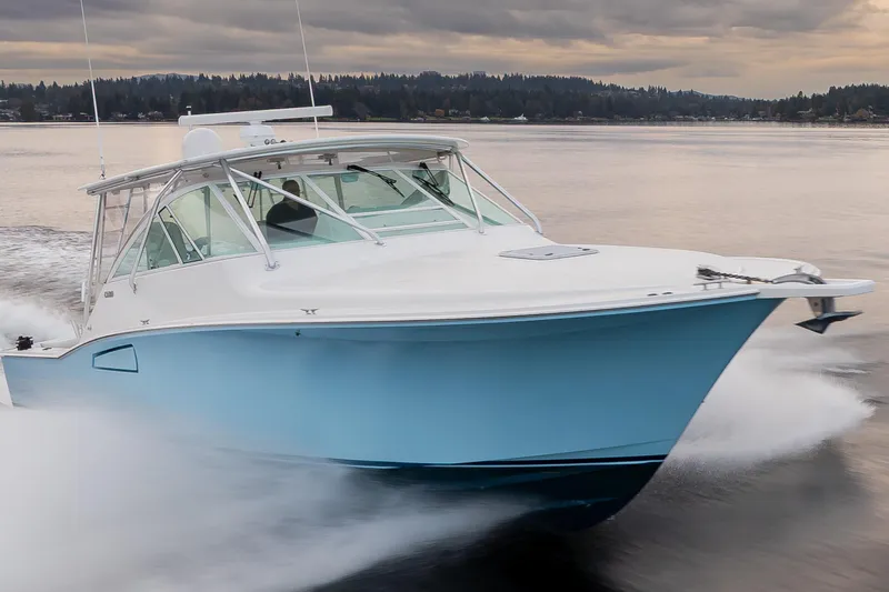  Yacht Photos Pics 2006 Cabo 40 Express boat cruising on a calm lake under cloudy skies.