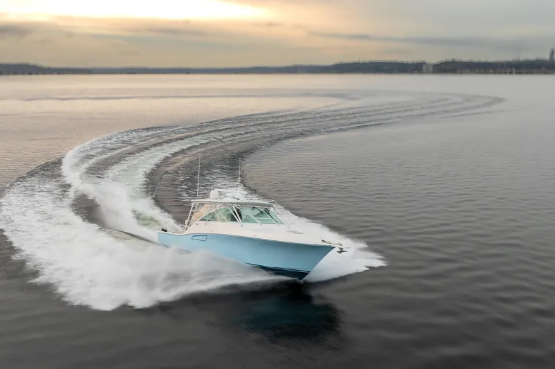  Yacht Photos Pics 2006 Cabo 40 Express yacht cruising swiftly on open water at sunset.