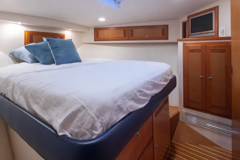 Yacht Photos Pics Luxurious cabin interior of 2006 Cabo 40 Express yacht with cozy bedding and wooden cabinetry.