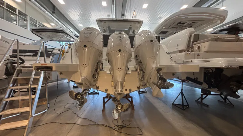  Yacht Photos Pics 2024 Jeanneau Leader 12.5 WA with triple outboard engines in a showroom.