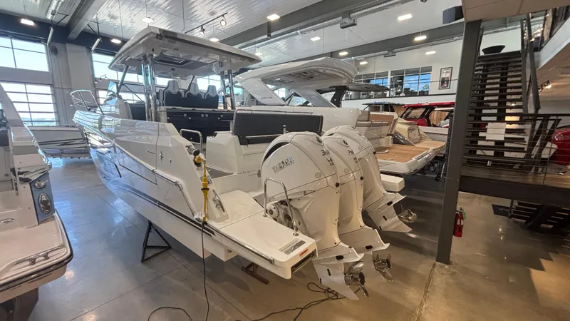  Yacht Photos Pics 2024 Jeanneau Leader 12.5 WA boat in showroom, featuring triple Yamaha outboard engines.