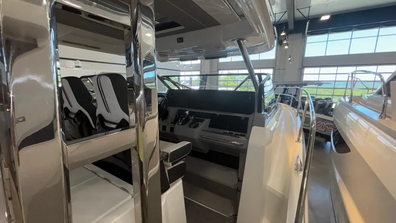  Yacht Photos Pics 2024 Jeanneau Leader 12.5 WA interior showcasing helm and seating area in a showroom.