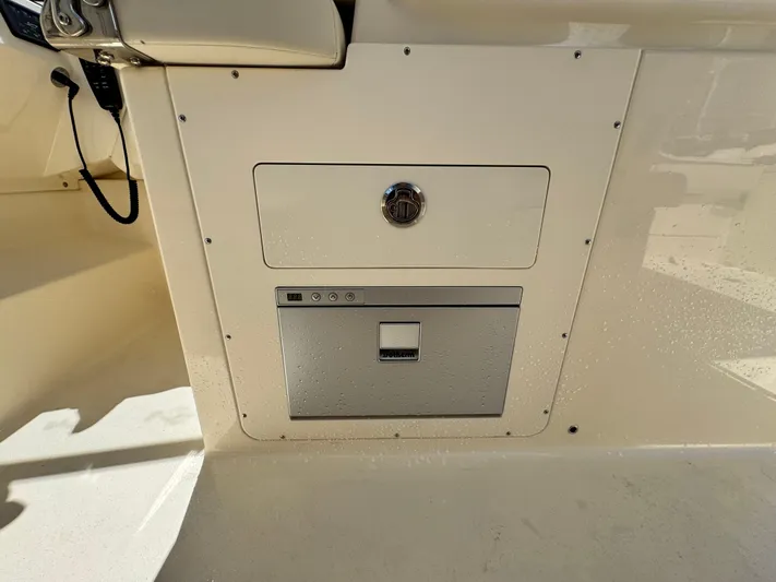  Yacht Photos Pics 2025 Scout 277 Dorado boat interior with storage compartment and control panel.