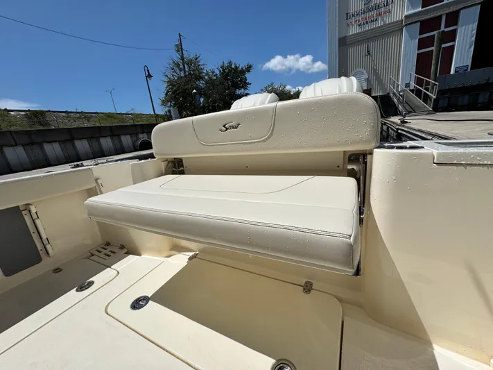  Yacht Photos Pics 2025 Scout 277 Dorado boat seat with wet upholstery, docked under clear blue sky.